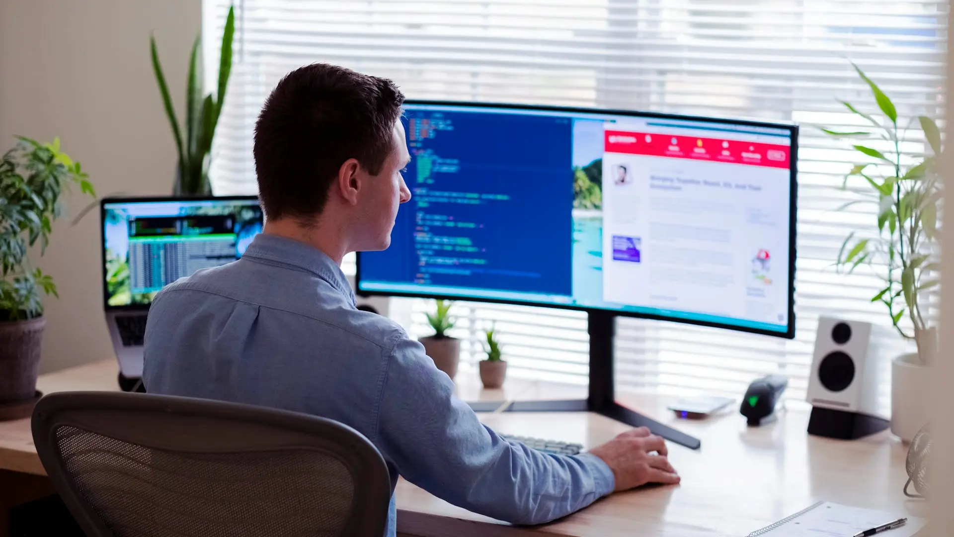 man in gray dress shirt sitting on chair in front of computer monitor