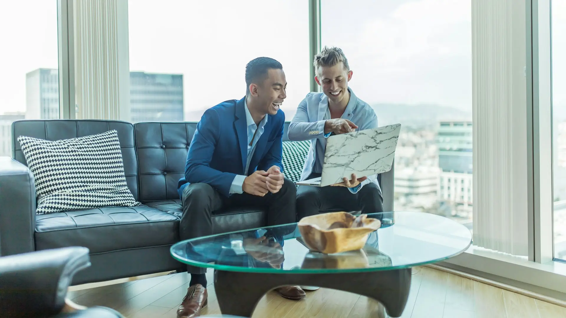 two men in suit sitting on sofa